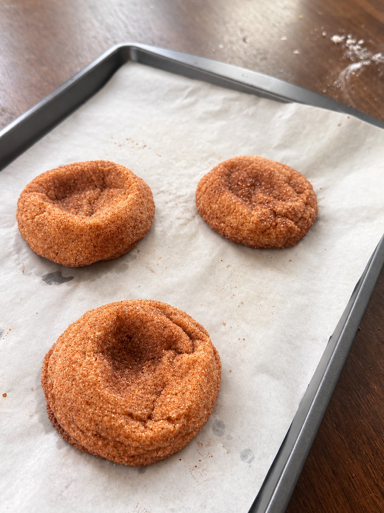 Freshly baked pumpkin spice cookies cooling on a sheet pan straight from the oven.